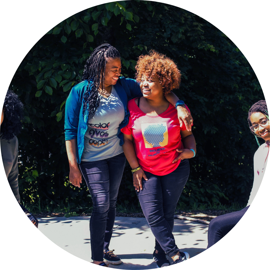 Two women sitting next to another pair of women with arms around each other