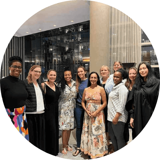 Dr. Andrea Peters smiling posed with a group of people