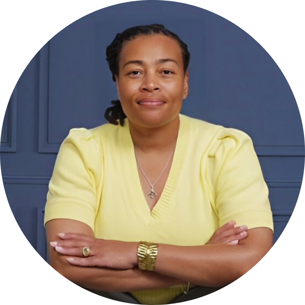 Dr. Andrea M Peters with arms crossed in front of a blue wall
