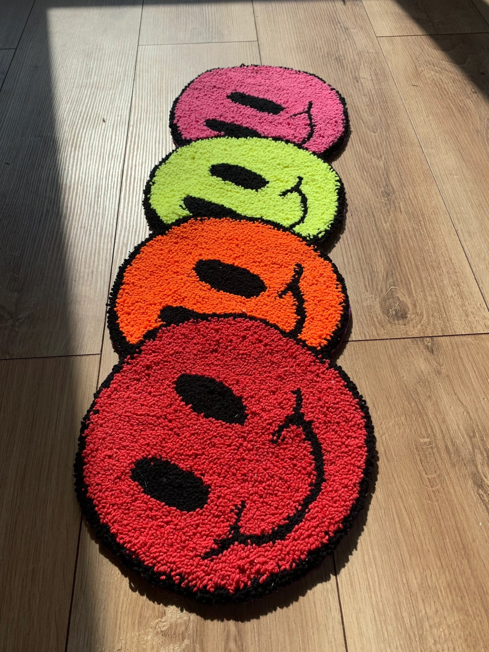Smiley face rugs in red, orange, yellow and pink