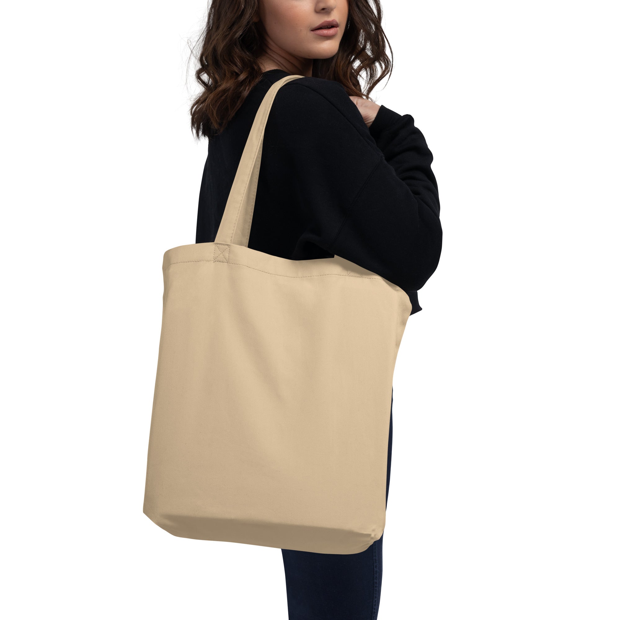 A woman holding an oyster-colored eco-tote bag.