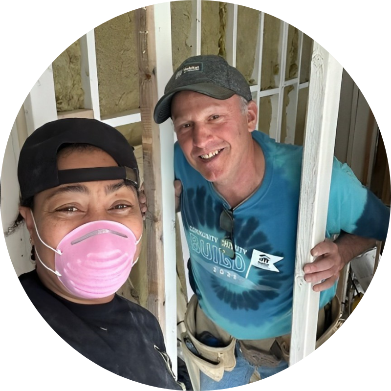 Dr. Andrea Peters and a volunteer working together to build a house for Habitat for Humanity.