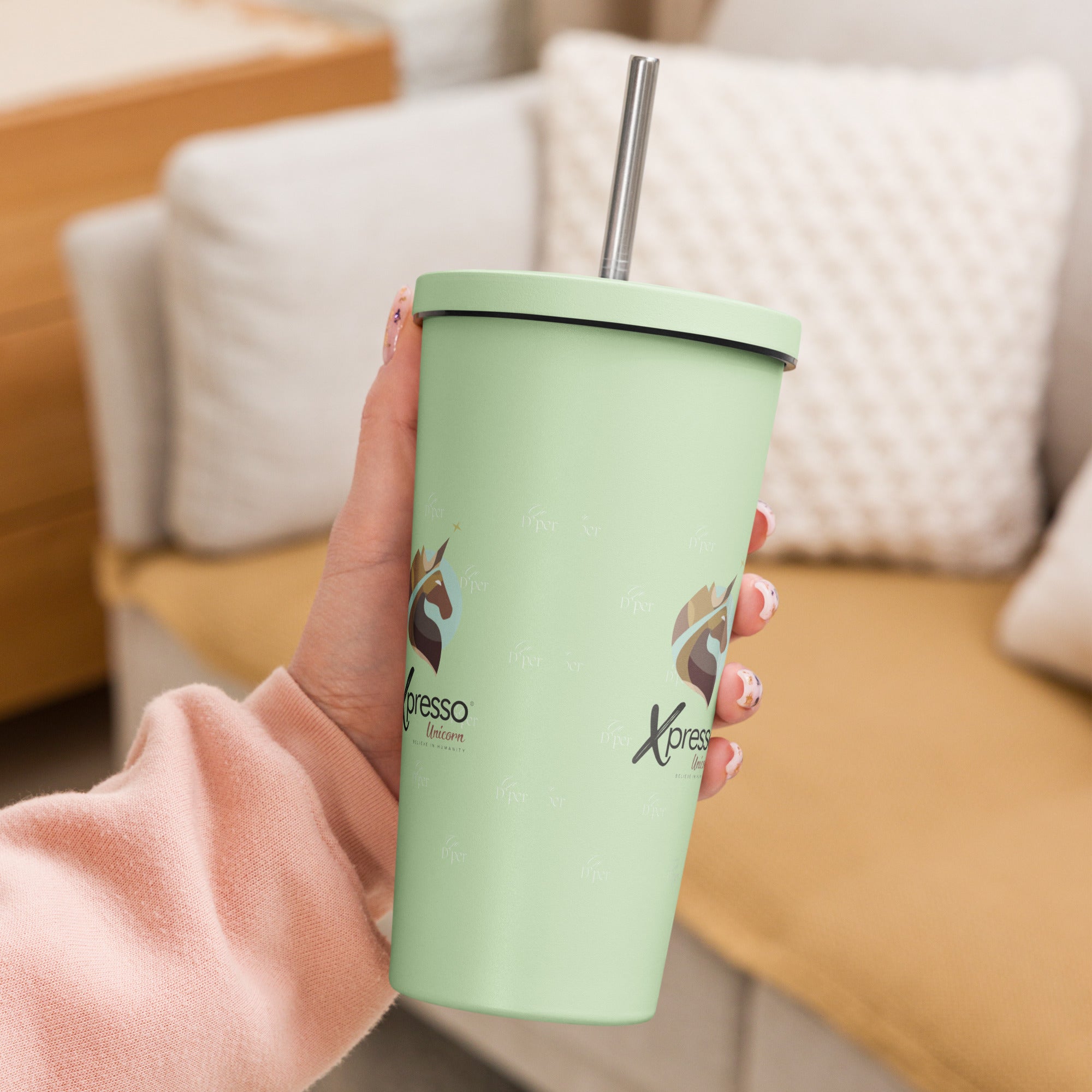 Mint green Xpresso Unicorn tumbler with a straw, held in someone's hand. Perfect for staying hydrated on the go.