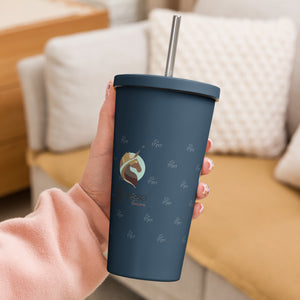 A hand holding a navy blue Xpresso Unicorn tumbler with a straw, ready for a refreshing drink.