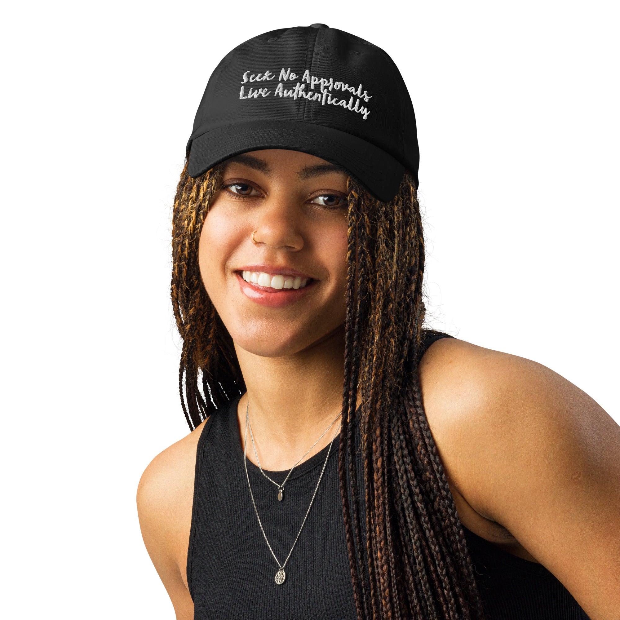 A Black woman with stylish braids looking sporty in a black Under Armour hat.