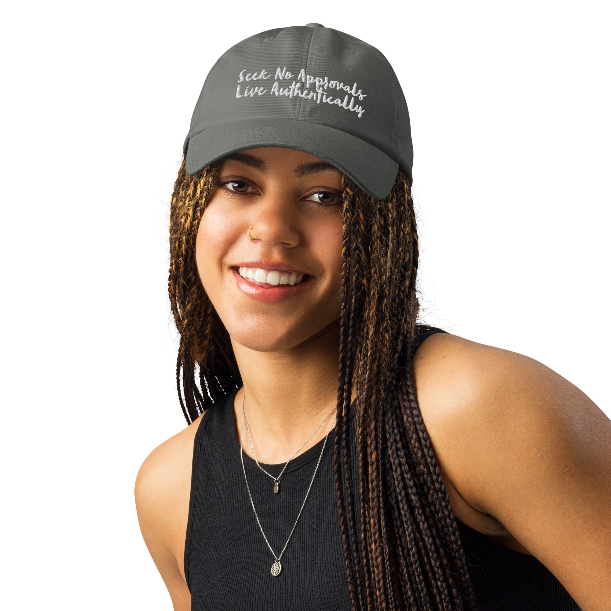 A Black woman with braids wearing a gray Under Armour hat.