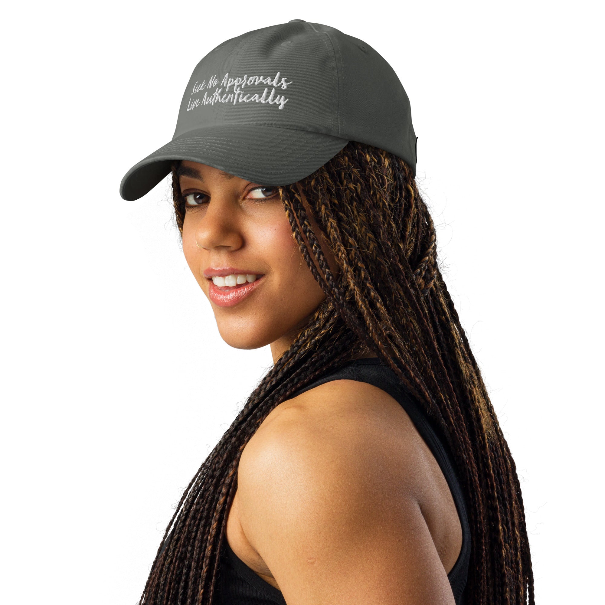 A gray Under Armour hat worn by a Black woman with braids, showcasing the hat's versatility and style.