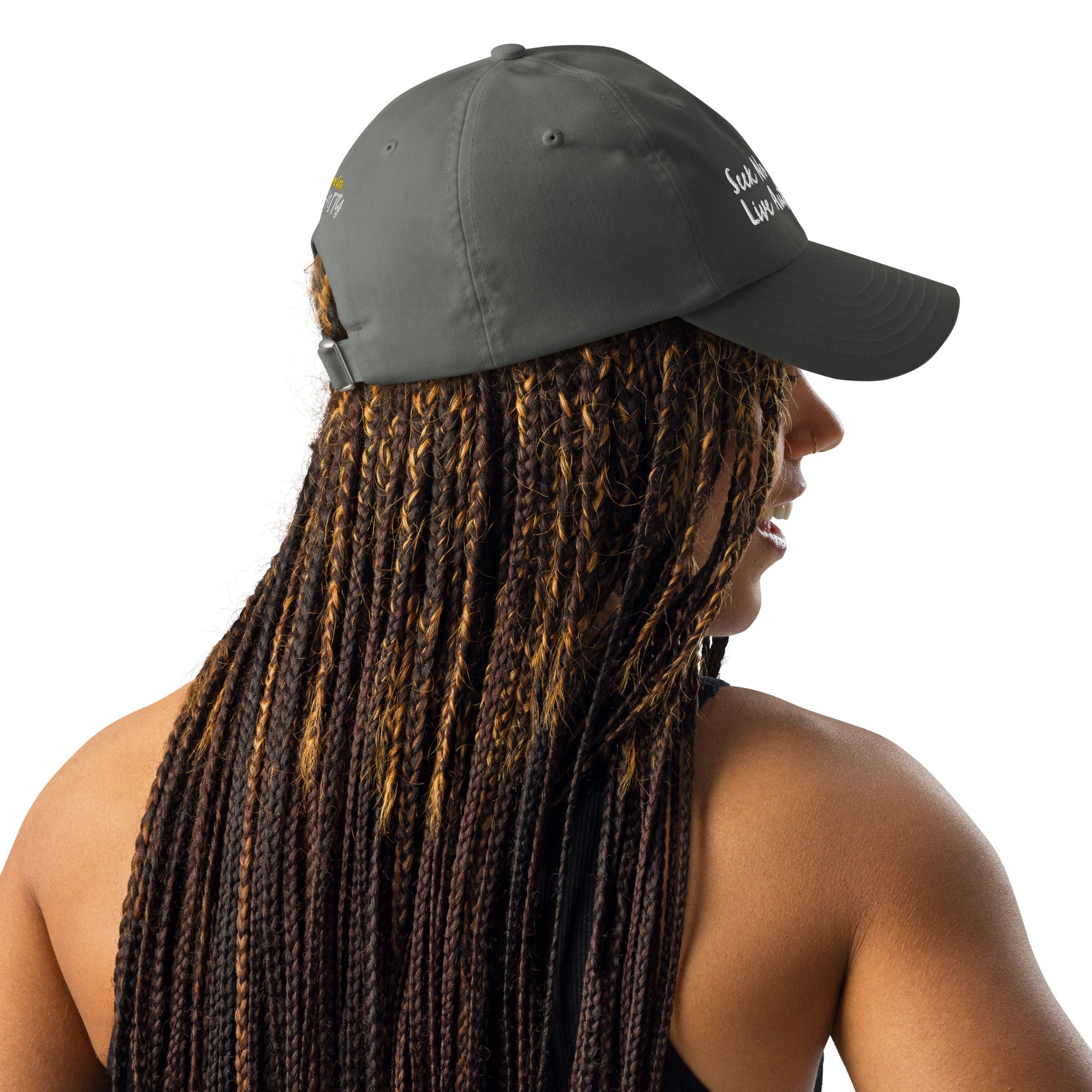 A Black woman with stylish braids looking sporty in a gray Under Armour hat.