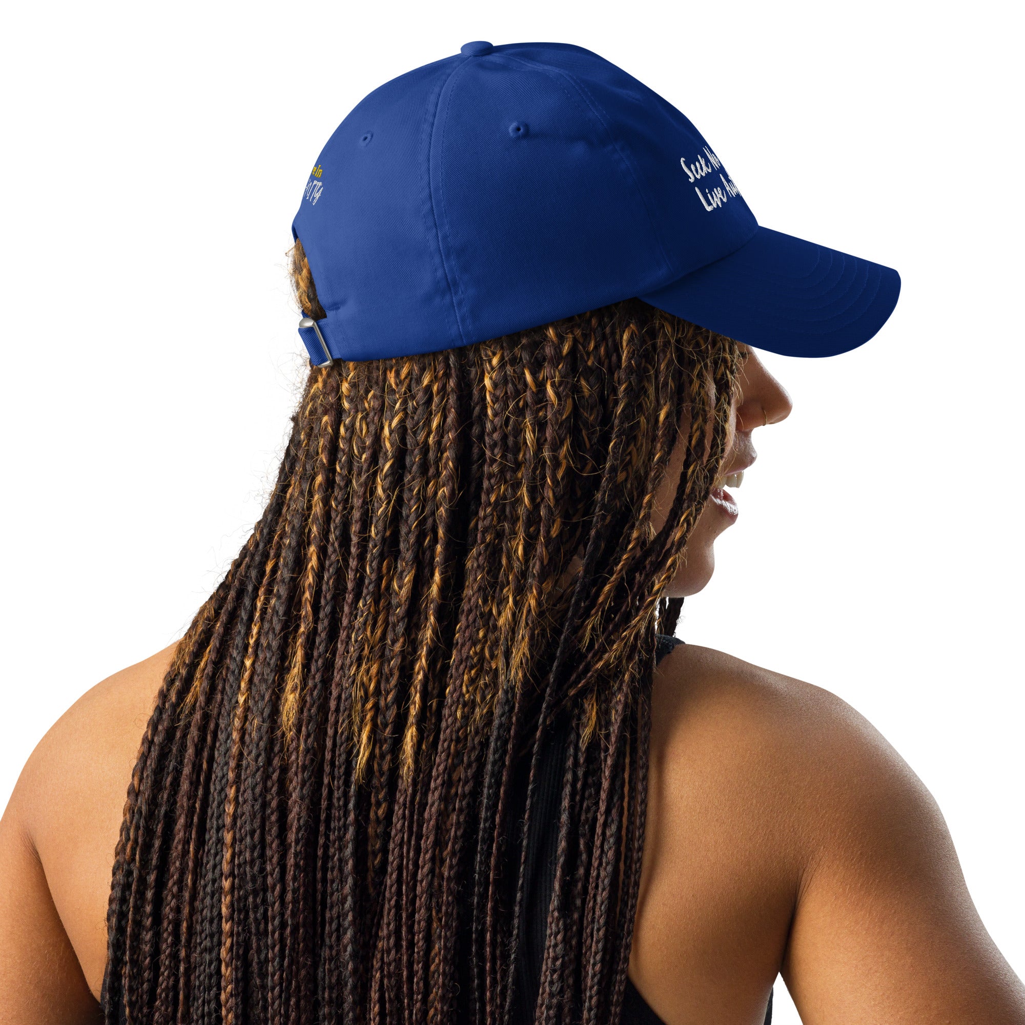 A Black woman with braids wearing a gray Under Armour hat in royal blue.