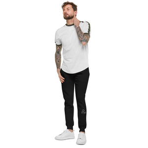 A man with tattoo sleeves showcasing a pair of comfortable, unisex black fleece sweatpants.