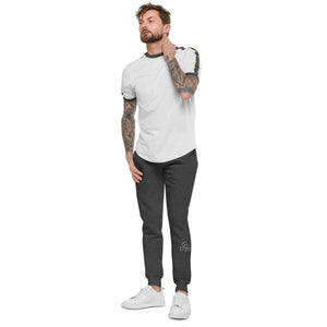 A man with tattoo sleeves showcasing a pair of comfortable, unisex charcoal heather fleece sweatpants.