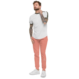 A man with tattoo sleeves showcasing a pair of comfortable, unisex dusty rose fleece sweatpants.