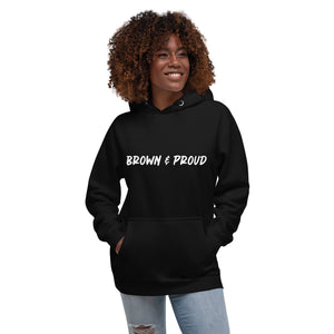 A person of color proudly wears a black hoodie featuring the words "Brown & Proud," celebrating their heritage.