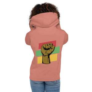 A powerful statement piece: a dusty rose hoodie with a raised black fist on the back, worn by a Black woman. The image represents resilience and the fight for equality.