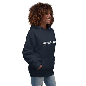 A Black woman exudes confidence, wearing a navy blue hoodie emblazoned with the phrase "Brown & Proud."