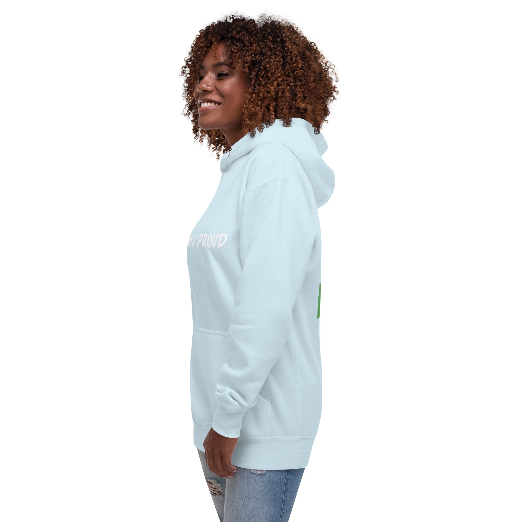 A Black woman smiles, sporting a sky blue hoodie with the words "Brown & Proud" printed boldly across the chest.