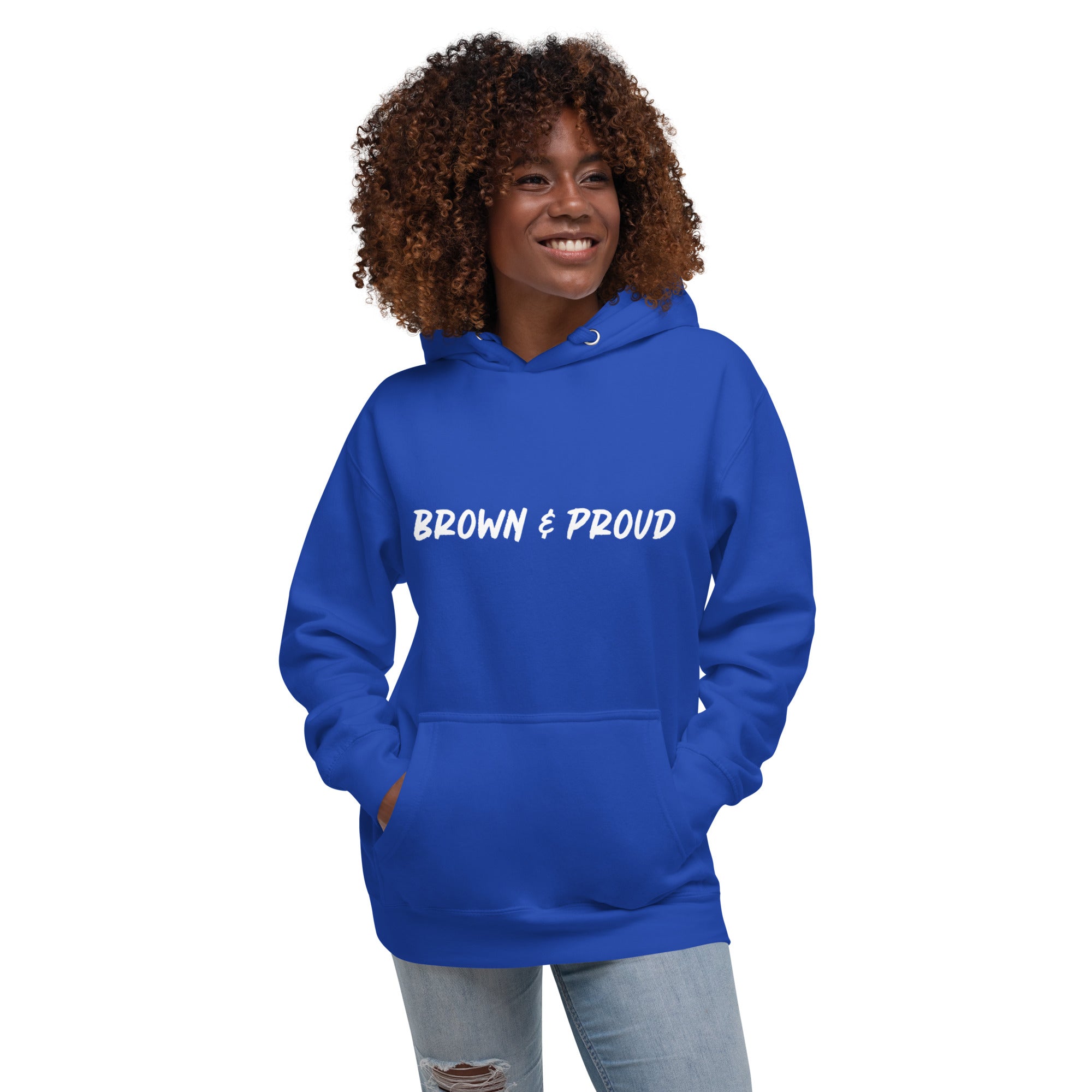 A person of color proudly wears a royal blue hoodie featuring the words "Brown & Proud," celebrating their heritage.